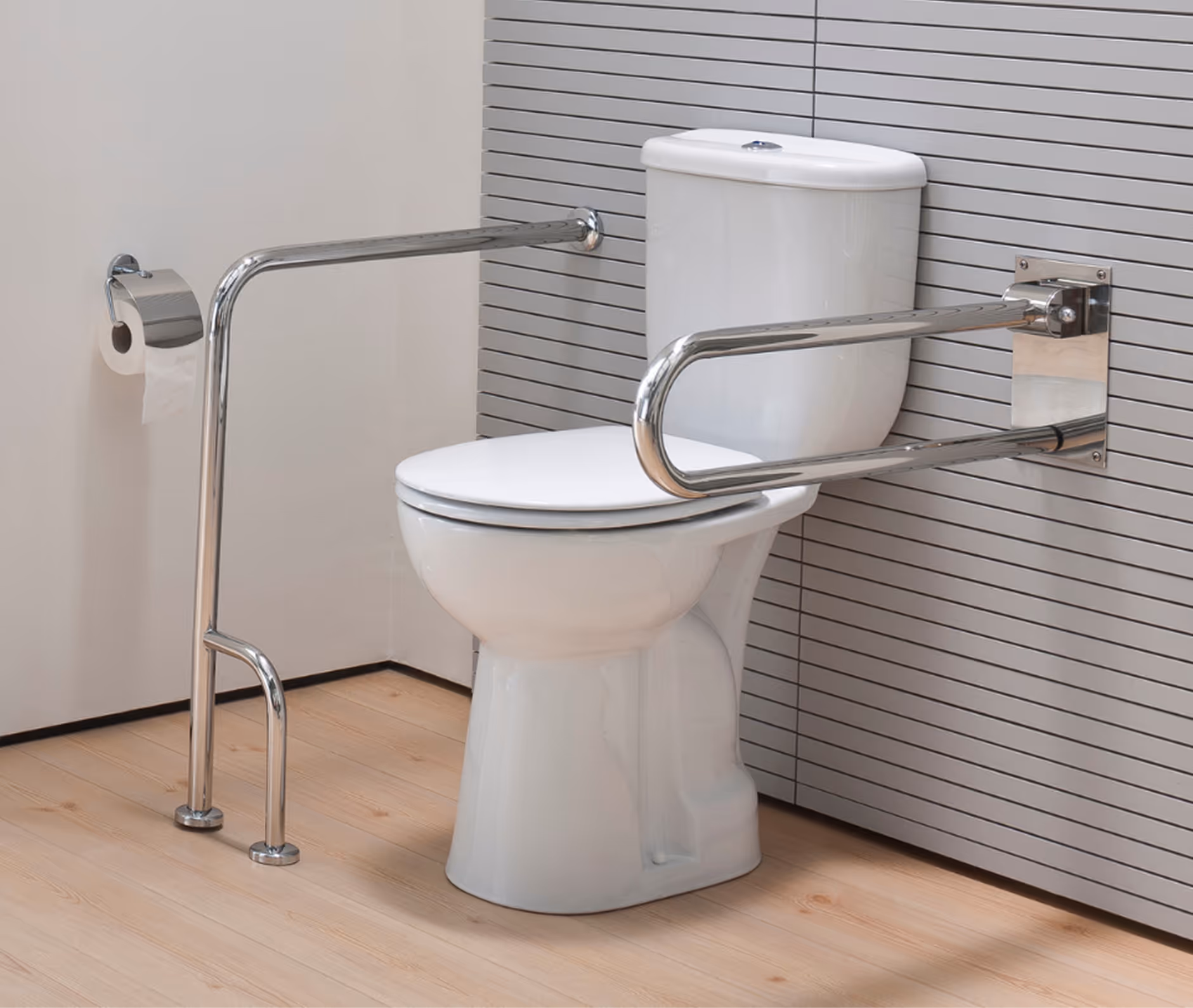 Weißes WC mit seitlichen Haltegriffen aus Edelstahl und einem Toilettenpapierhalter an der linken Wand in einem Badezimmer mit Holzboden.