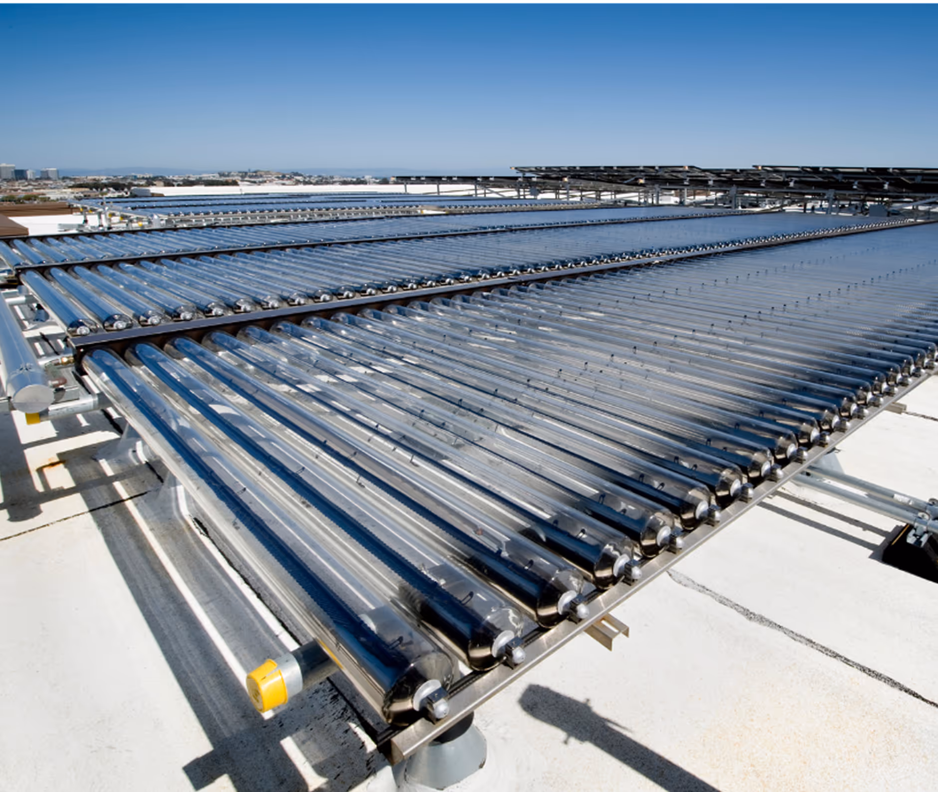 Dachinstallation mit mehreren Reihen von Vakuumröhren-Solarkollektoren unter klarem Himmel.